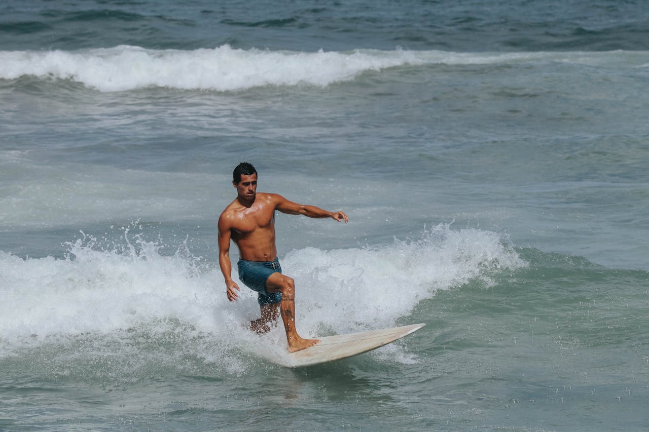 Surfer expertly riding the waves on a sunny day at the beach.